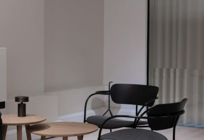 Lounge area with mid-century style black chairs and a paper globe pendant light.