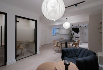 Modern communal space with round tables, paper lantern lights, and soft seating.