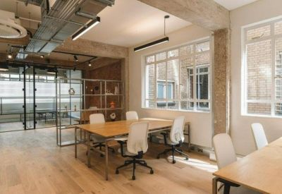 Modern meeting room enclosed by industrial glass doors with a wooden table and white chairs.