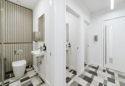 Modern restroom area with patterned tile flooring and vertical wood slat walls.