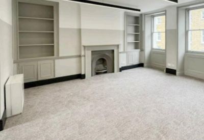 Private office suite with a classic fireplace and built-in shelving units.