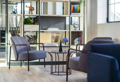 Stylish lounge area featuring grey and blue armchairs and a decorative display shelf.