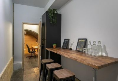 Narrow workspace corridor with a wooden breakfast bar and stools.