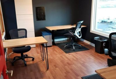 Private office space with wooden floors and two workstations.