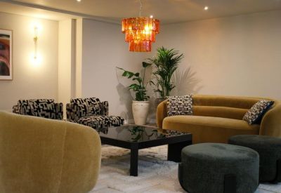 Elegant lobby lounge with mustard yellow seating and a tiered orange chandelier.