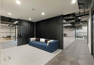 Lounge area with a blue sofa set against a black slatted timber feature wall.