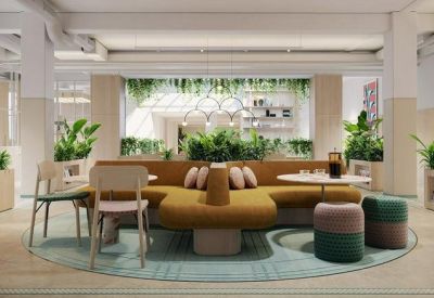 Breakout space with a unique tan modular sofa, green ottomans, and integrated shelving with plants.