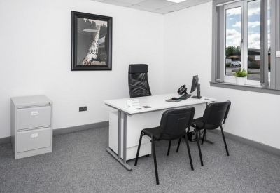 Private office suite with a white desk, filing cabinet, and framed artwork.