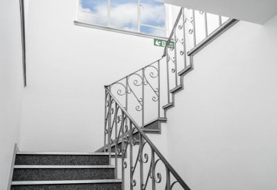 Internal staircase featuring white walls and decorative wrought iron railings.