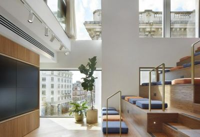 Amphitheater-style wooden seating area with blue cushions and city views.