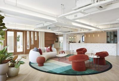 Bright reception area with a curved white sofa and colorful circular rug.