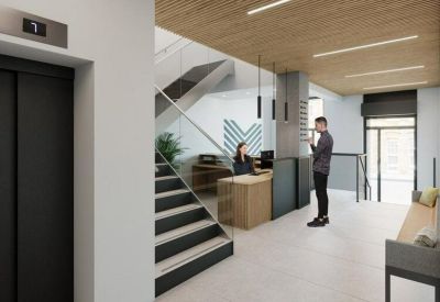 Reception area with a wooden slat ceiling, minimalist front desk, and a modern staircase.