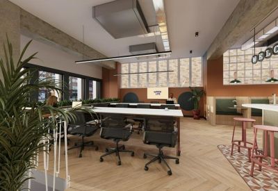 Open-plan workspace with chevron wood flooring and a large communal desk.