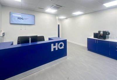 Bright reception area featuring a bold blue desk with HQ branding.