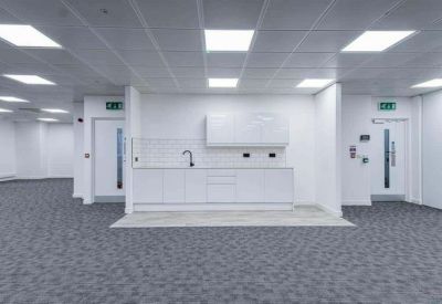 Bright communal kitchen area with white cabinetry and minimalist fixtures.