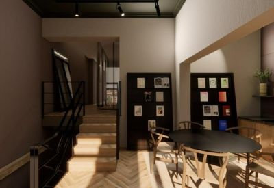 Bright workspace featuring a communal dining table and library-style book displays.