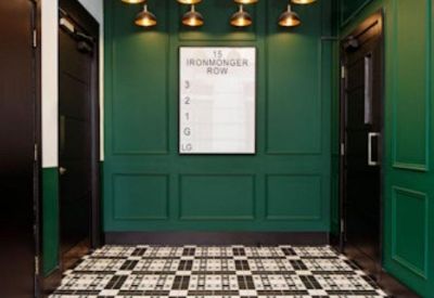 Stylish entrance lobby with green paneled walls, decorative pendant lights, and patterned tiling.