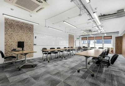 Meeting room with long tables and a feature brick wall.