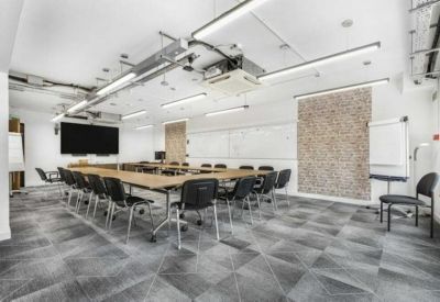 Large boardroom featuring a U-shaped table and exposed ceiling.