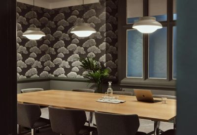 Sophisticated meeting room with cloud-patterned wallpaper and a large wooden conference table.