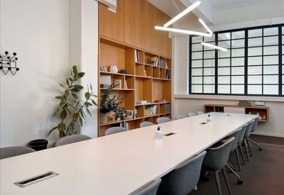 Private wooden seating booths with grey upholstery and pendant lighting for quiet work.
