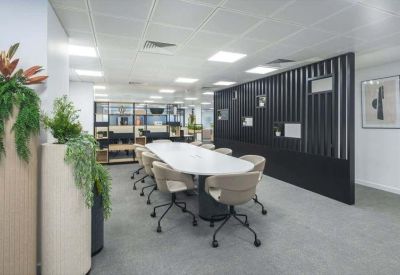 Professional meeting room featuring a long oval table and a dark slatted feature wall.