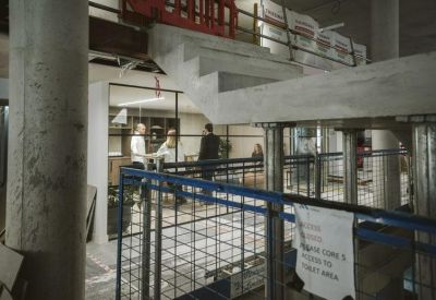 Office interior view through a glass partition showing people in a collaborative meeting.