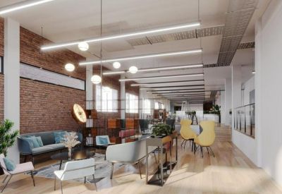 Bright communal lounge with exposed brick walls, modern seating, and long linear pendant lights.