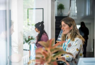 Bright reception desk with staff and potted plants.