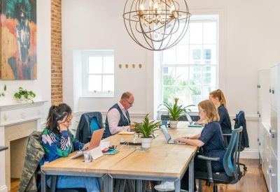 Spacious open-plan office with high ceilings and large windows.