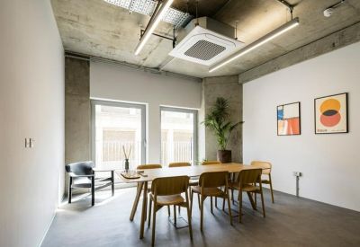 Bright meeting room with a wooden table, concrete accents, and abstract art.