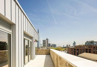 Sunny rooftop terrace with views of the London city skyline.