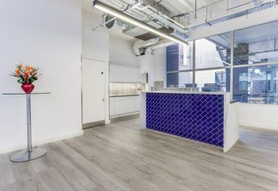 Modern reception area featuring a textured blue desk and exposed ductwork.