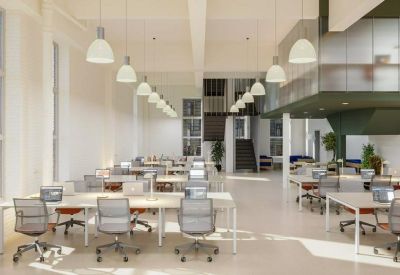 Spacious open-plan office with white desks and rows of pendant lighting.