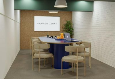 Modern meeting room featuring a blue oval table and cork feature wall.