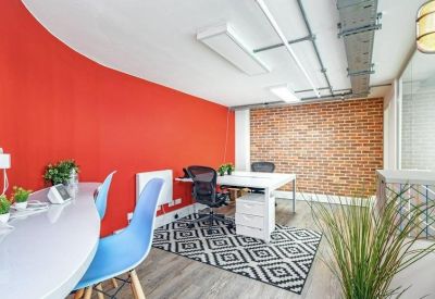 Private office space with a red wall and exposed brickwork.