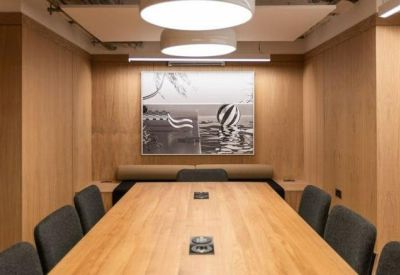 Modern meeting room with wood panelled walls and a large timber table.