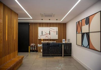 Modern reception area with a dark marble desk, wood-paneled walls, and geometric abstract art.