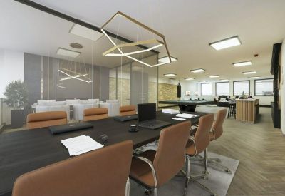 Professional boardroom with a long dark table, leather chairs, and a geometric chandelier.