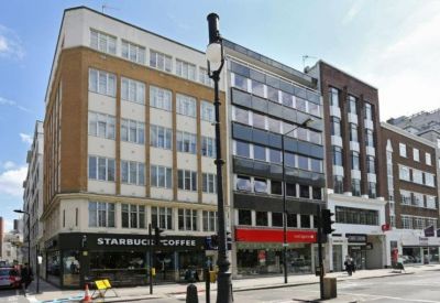Exterior view of the multi-story commercial building with a Starbucks on the ground floor.