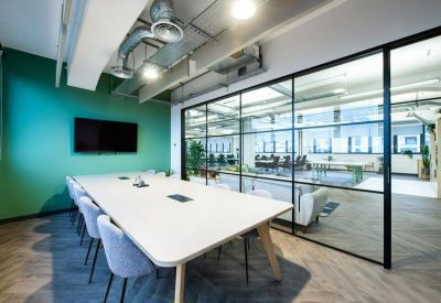 Bright conference room with a large white table and glass partitions.