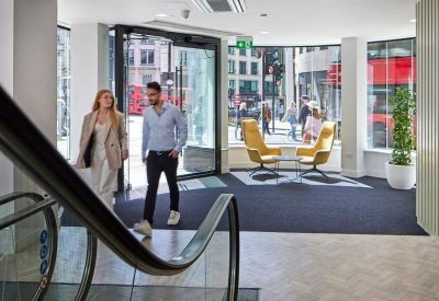 Building entrance lobby with yellow accent chairs and views of the street.
