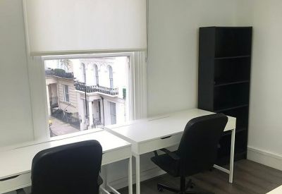 Office suite with dual white workstations and a black bookshelf against a neutral wall.