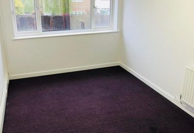 Private office suite featuring purple carpeting and a wide window for natural light.