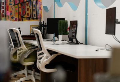 Workstations featuring a wavy partition wall and colorful abstract wall art.