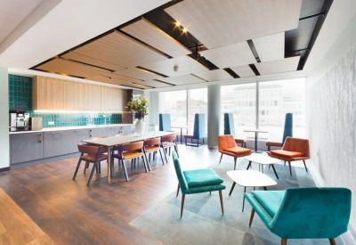 Modern communal kitchen and dining area with teal and orange seating.