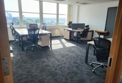 Bright open-plan office with ergonomic chairs and large windows.