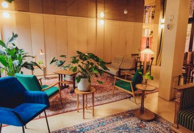Mid-century style lounge area with colorful velvet armchairs and patterned rugs.