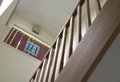Internal staircase with light wood banisters and a branded window decal.