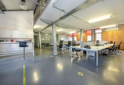 Versatile coworking area with high ceilings, industrial details, and plenty of natural light.